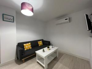 a living room with a black couch and a white table at Vivienda Casa Gabi in Úbeda