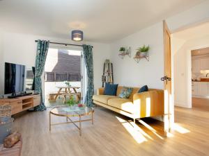 uma sala de estar com um sofá e uma mesa em Crosshill Cottage em Honiton