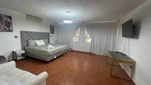 a bedroom with a bed and a couch and a table at Casa Lomas in Tegucigalpa