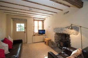 a living room with a couch and a fireplace at Penny Red Cottage in Ambleside