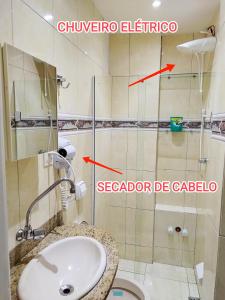 e bagno con servizi igienici, lavandino e doccia con soffione. di Quitinete ACONCHEGANTE a Rio de Janeiro