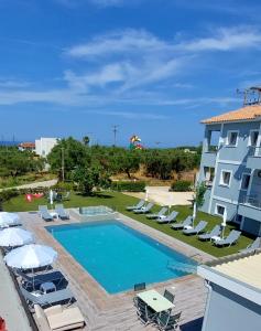 a swimming pool with lounge chairs and a building at GK Holiday Home in Tragaki