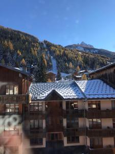 un bâtiment avec un toit et une montagne en arrière-plan dans l'établissement VALFREJUS résidence chaviere, à Modane