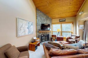 a living room with couches and a fireplace at Cozy Modern Comfort in Killington