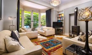 a living room with white couches and a tv at The Boundary in Windermere