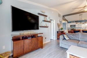 a living room with a large flat screen tv on a wall at The Sand Dune in Ocean City