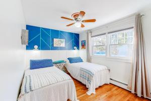 a bedroom with two beds and a ceiling fan at Childs River Hollow in East Falmouth
