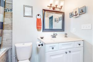 a bathroom with a toilet and a sink and a mirror at The Sand Dune in Ocean City