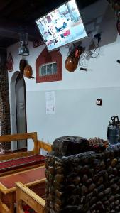 telewizor z płaskim ekranem wiszący nad stołem w pokoju w obiekcie Dar Agham Akbou w mieście Timimoun