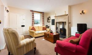 a living room with two couches and a fireplace at Kent Cottage in Cockermouth