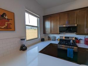 a kitchen with wooden cabinets and a stove top oven at Scenic Southwest Hideaway, Perfect for Relaxation! in Phoenix