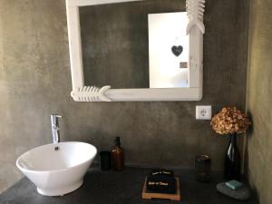 a bathroom with a white sink and a mirror at Casa da Arquinha in Santo Amaro