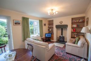 ein Wohnzimmer mit zwei Sofas und einem Kamin in der Unterkunft Sunset Cottage in Ambleside