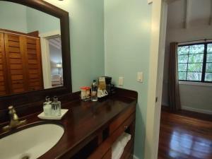 uma casa de banho com um lavatório e um espelho grande em Santa Cruz Cabins em Santa Elena