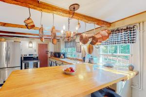 a kitchen with a wooden table with a bowl of fruit on it at Water Street Retreat in Sandwich