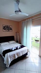 a bedroom with a bed and a large window at Casa Confortável, 3 Quartos, Ar Condic. 300 Mega, Taubaté in Taubaté