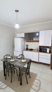 - une cuisine avec une table et des chaises dans la chambre dans l'établissement Casa Confortável, 3 Quartos, Ar Condic. 300 Mega, Taubaté, à Taubaté