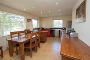 a kitchen with a wooden table and a dining room at Bield How in Ambleside