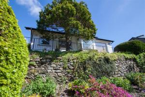 a house on top of a stone wall with flowers at Bield How in Ambleside