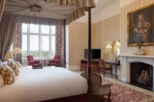 a bedroom with a bed and a desk and a fireplace at The Welcombe Hotel, Sure Hotel Collection by Best Western in Stratford-upon-Avon +139 photos