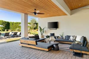 a living room with couches and a flat screen tv at Strut Oasis 70 - Play, Relax, Walk to Coachella Festival! in Indio