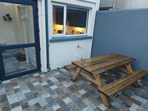 una mesa de picnic de madera sentada fuera de una ventana en AMY'S Place Charming 3 Bed House Donegal, en Donegal