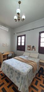 Un dormitorio con una cama grande y una lámpara de araña. en Casa 307, en Manaus