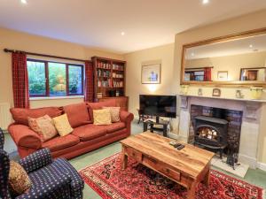 a living room with a red couch and a fireplace at Low House in Penrith