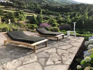 two beds on a patio with a view of a mountain at Casa da Arquinha in Santo Amaro