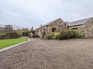 an old stone house with a gravel driveway at Low House in Penrith