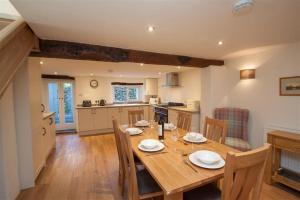 a kitchen and dining room with a wooden table and chairs at Mylnbeck in Windermere