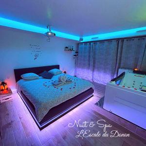 um quarto com uma cama com luzes roxas em L'escale du Donon "Le Jardin Secret" em Grandfontaine