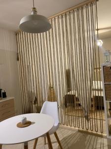 a white table and chairs in a room with a large vertical fence at Macadà in Bari
