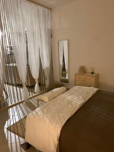 Schlafzimmer mit einem Bett und einem Fenster mit Vorhängen in der Unterkunft Macadà in Bari