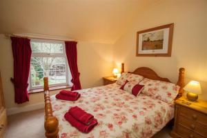 a bedroom with a bed with red pillows on it at Bleaberry Cottage in Penrith