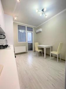 ein Wohnzimmer mit einem Tisch und Stühlen im Zimmer in der Unterkunft Beautiful Apartment in Chisinau in Chişinău