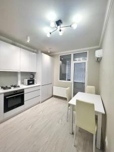 a kitchen with a table and chairs in a room at Beautiful Apartment in Chisinau in Chişinău