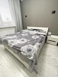 a bedroom with a bed with a comforter on it at Beautiful Apartment in Chisinau in Chişinău