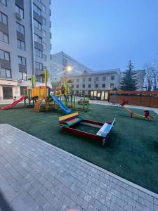 einen Spielplatz mit Rutschen und Spielgeräten in einer Stadt in der Unterkunft Beautiful Apartment in Chisinau in Chişinău