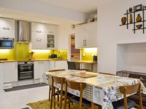 a kitchen with a table and chairs with yellow at Retro Retreat in Filey