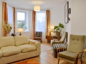 a living room with a couch and two chairs at Retro Retreat in Filey