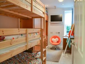 a bunk bed room with two bunk beds and a desk at Retro Retreat in Filey