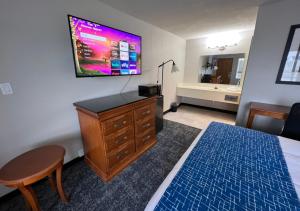 1 dormitorio con tocador y TV en la pared en Travelodge by Wyndham Lincoln Northeast, en Lincoln