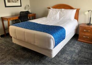 a bed in a hotel room with a desk and a bed sidx sidx sidx sidx at Travelodge by Wyndham Lincoln Northeast in Lincoln