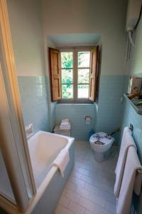 a bathroom with a tub and a toilet at Agriturismo Villa Cavallini in Camaiore