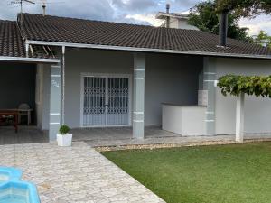 una casa con una puerta blanca y un patio en Aconchegante casa com piscina, en Florianópolis