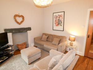 uma sala de estar com um sofá e uma lareira em Hazeldene em Ambleside