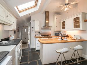 uma cozinha com armários brancos e uma clarabóia em Hazeldene em Ambleside