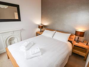 ein Schlafzimmer mit einem weißen Bett mit zwei Handtüchern darauf in der Unterkunft Hazeldene in Ambleside