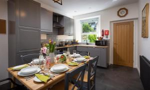 eine Küche mit einem Holztisch mit Tellern und Geschirr darauf in der Unterkunft Fell Cottage in Ambleside